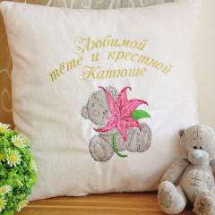 A pillow with a teddy-bear holding a lily embroidery design