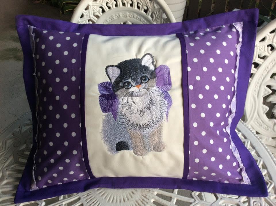 Embroidered pillow with kitty in bow design