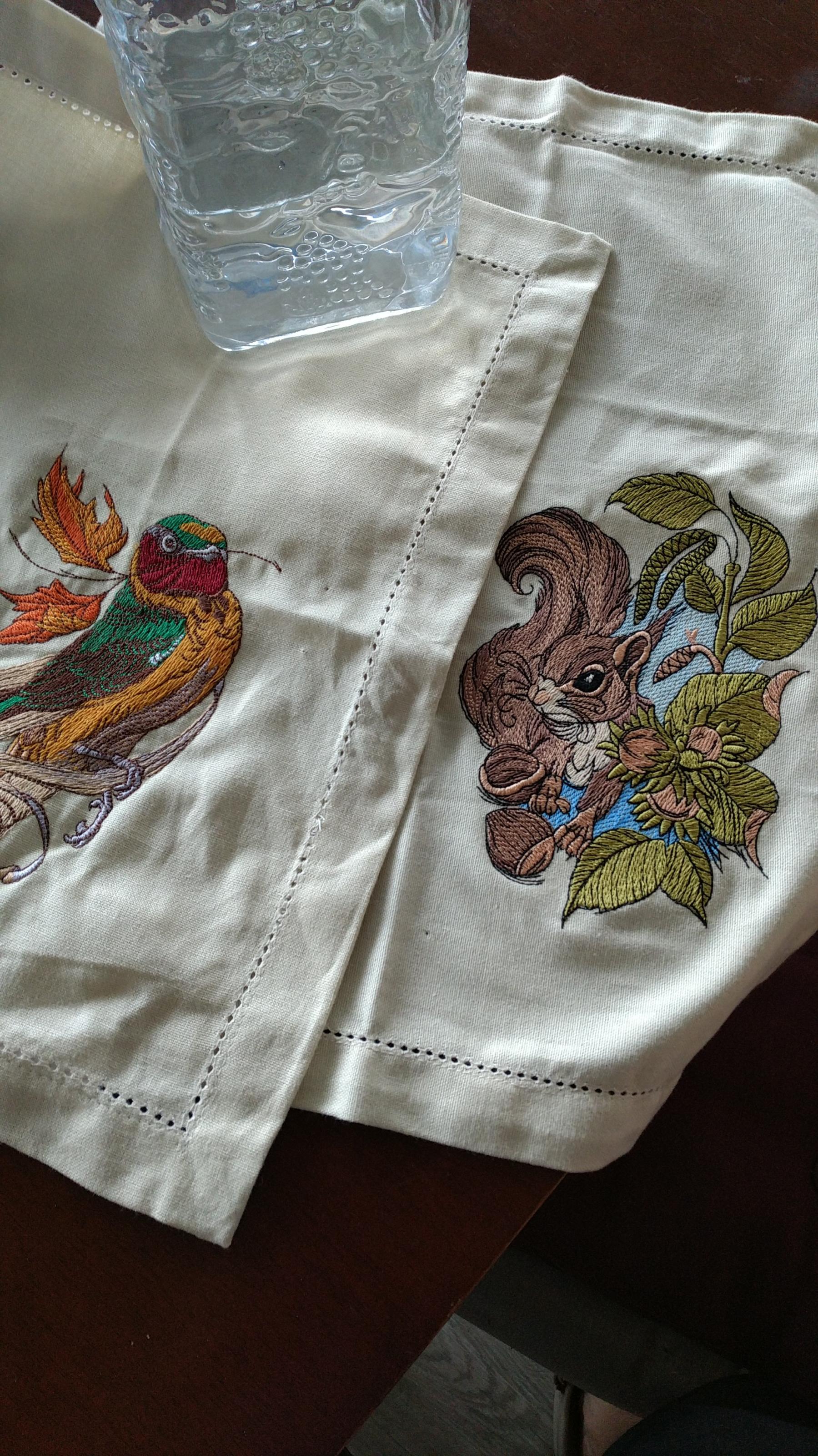 Embroidered napkin with siberian rubythroat and squirrel designs