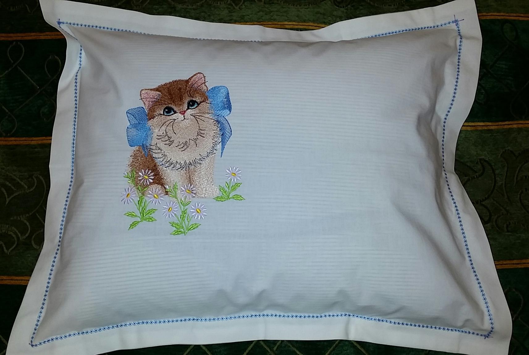 Embroidered pillow with kitty and bow design