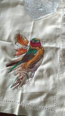 Embroidered napkin with colorful bird design