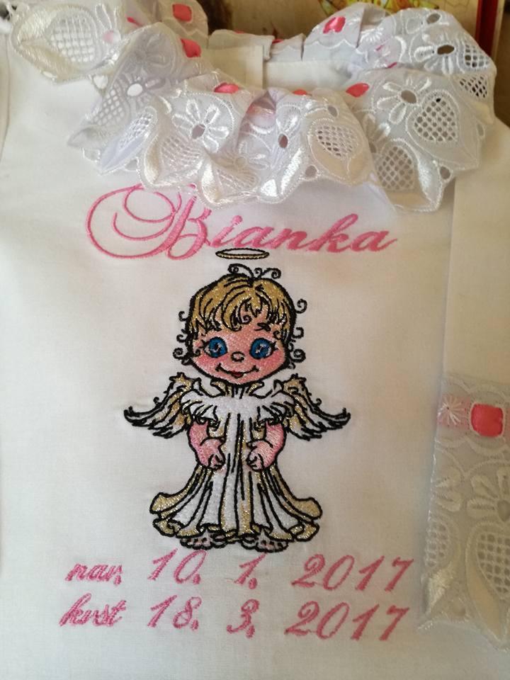 Fragment of embroidered baby girl dress with little angel design