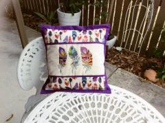 Embroidered cushion with rainbow feathers designs