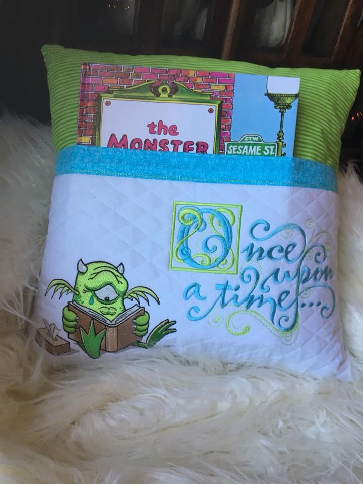 Embroidered pillow with reading alien design
