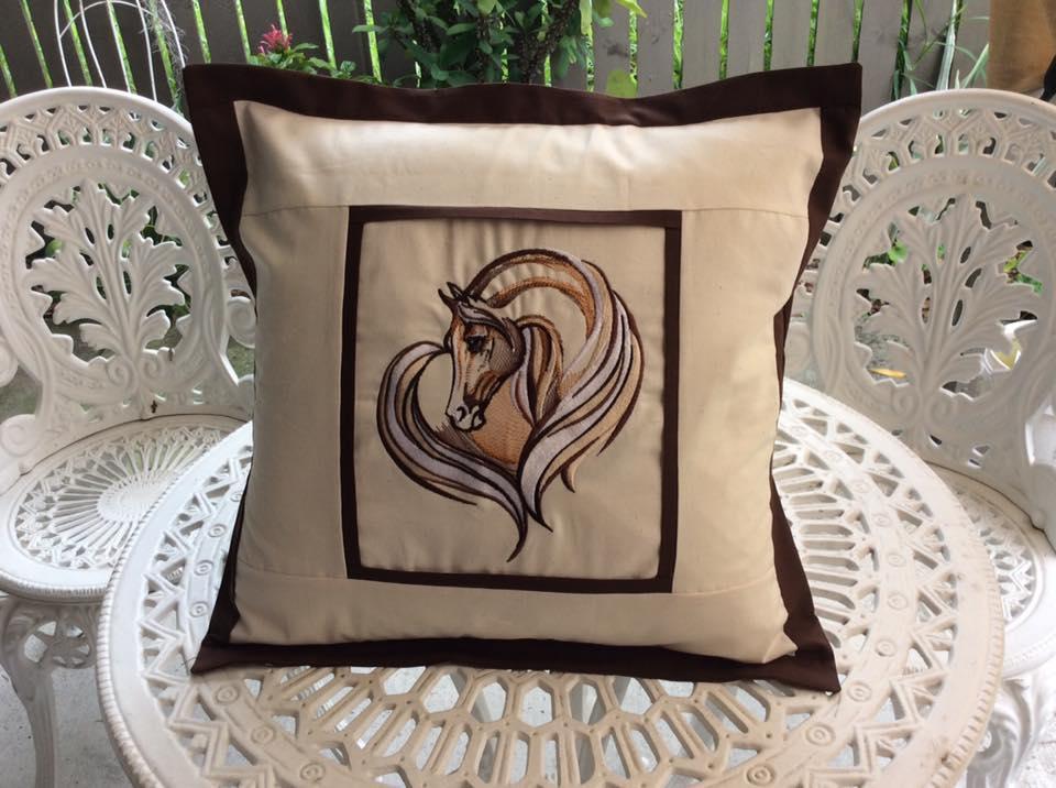 Decorative pillow with a sad horse machine embroidery design