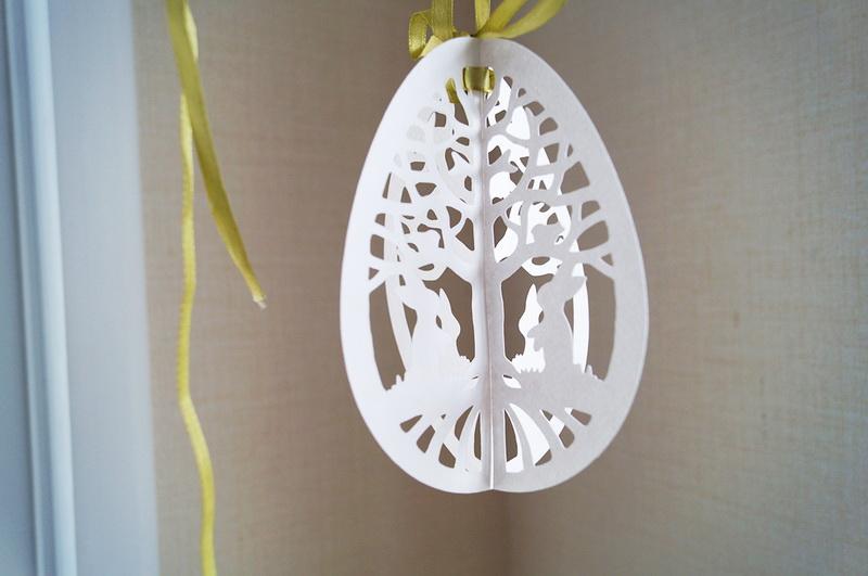 Adding ribbon White paper Easter egg with ribbon