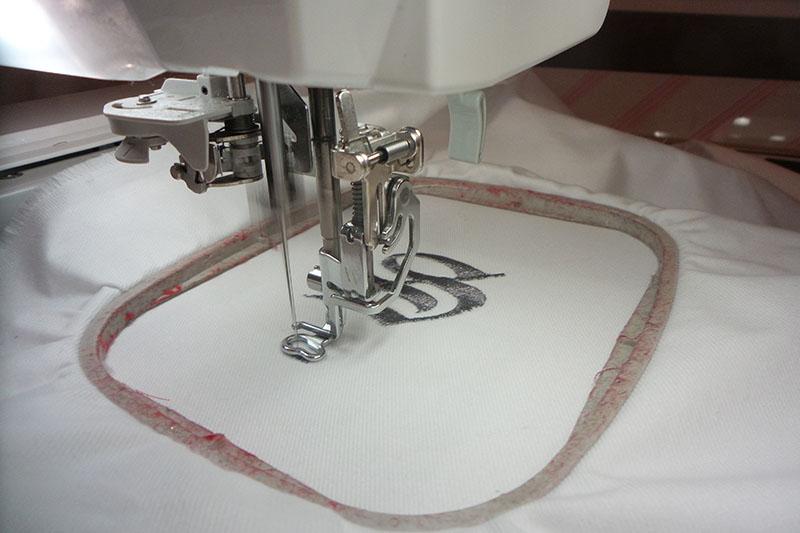 Embroidering a silver letter Silver letter embroidery on white fabric