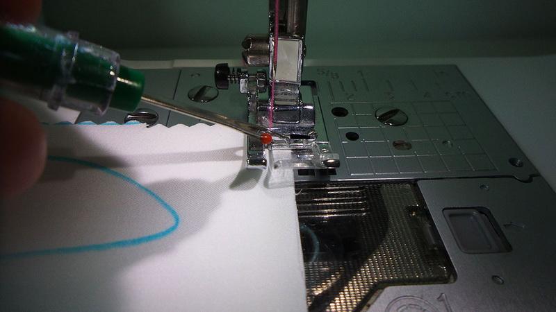Stitching two pieces of fabric together Pink upper thread and turquoise lower thread