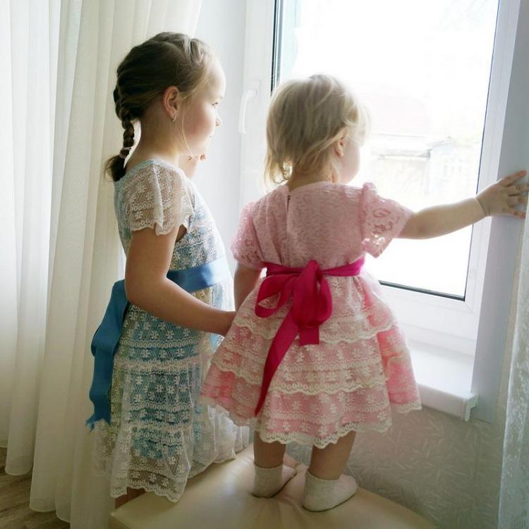 Two small girls in lacy dresses