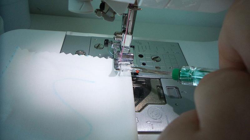 Scale on the pressing foot Pieced of white fabric under presser foot
