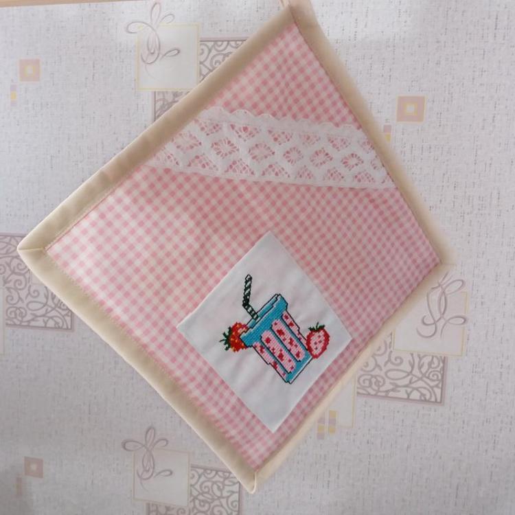 A ready pot holder An embroidered pot holder with binding and lace
