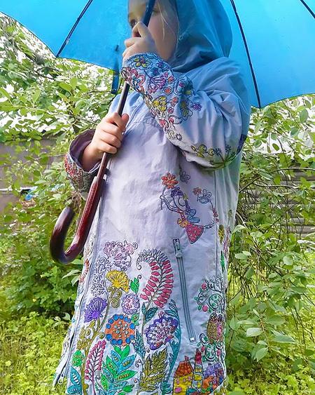 A child in a decorated raincoat A child in an embroidered and colored raincoat