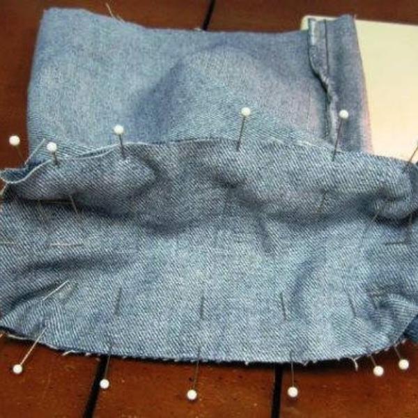 Parts of a denim backpack secured with pins